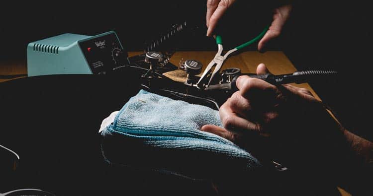 person installing pots into guitar